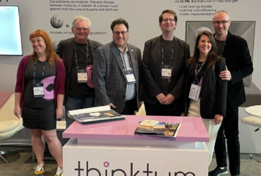 Group photo of thinktum staff at the thinktum booth at InsurTech NY 2022.